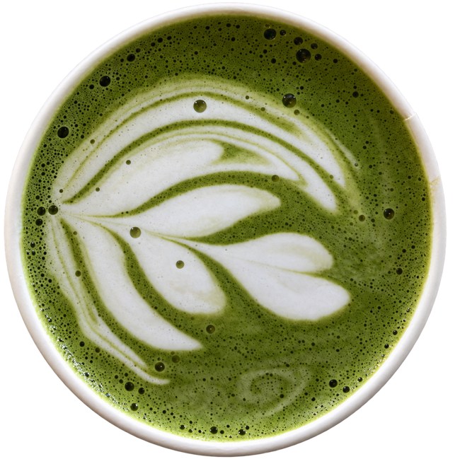 A cup of green matcha with leaf-shaped latte art, viewed from above.